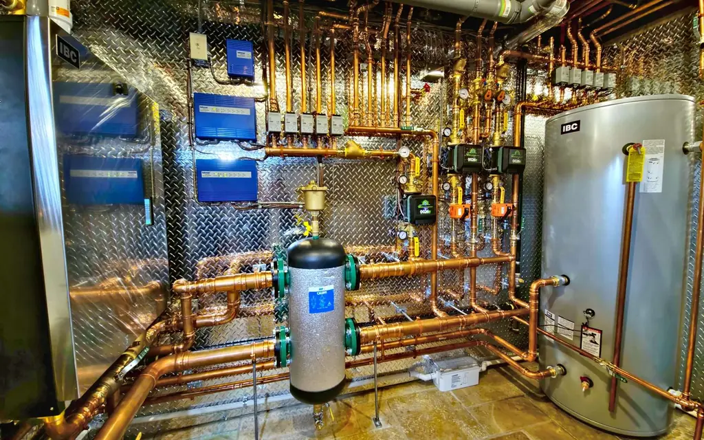 Renovated mechanical room with copper piping, a high-efficiency boiler and an indirect hot water tank