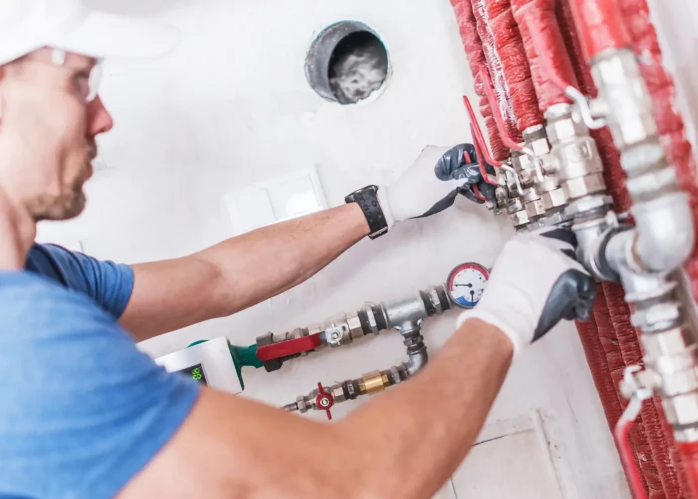 Plumber connecting a radiant floor heating manifold, plumbing and heating service in Markham